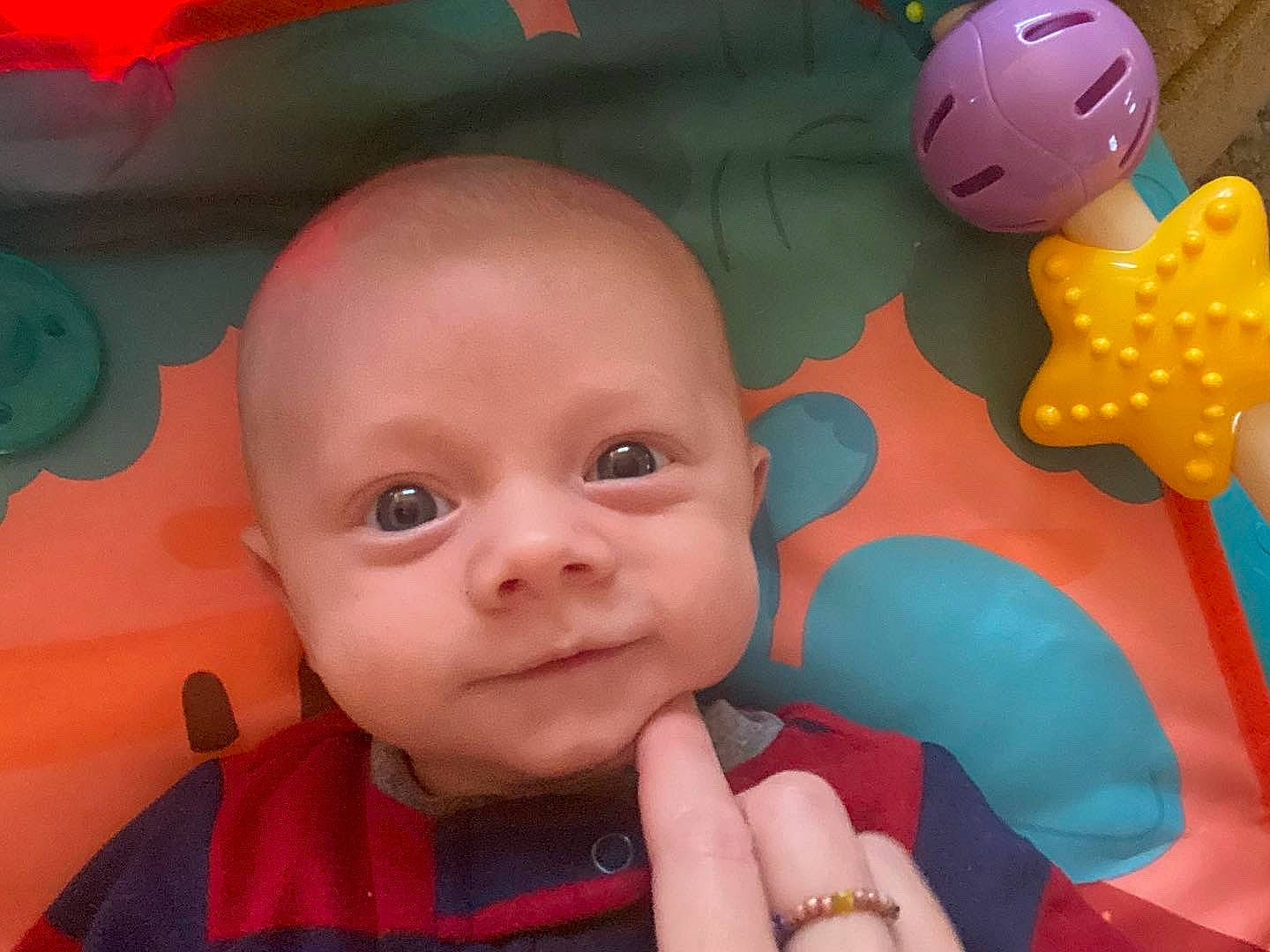 Charlie is registered to the contest to win money with this photo: baby, cheek, finger, fun, gesture, happy, mouth, nose, orange, organ, person, pink, product, red, skin, smile, snapshot, textile, thumb, toddler