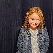 Alyvia is registered to the contest to win money with this photo: blonde_hair, brown_boots, carpet, casual_clothing, child, curly_hair, curtain, denim_jacket, fashion, full_body, girl, happy, indoor, lace_dress, person, photography, portrait, smiling, standing, western_style