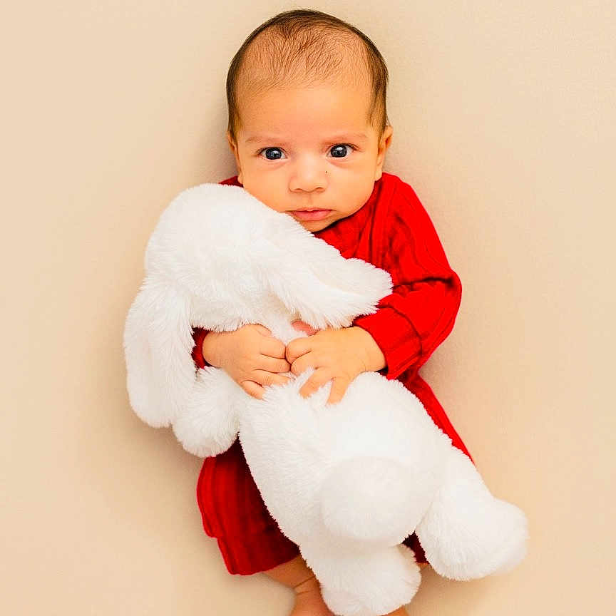 Aaryan joined the competition — help win amazing prizes! baby, infant, red_clothing, stuffed_animal, white_bunny, plush_toy, cute, portrait, child, soft_texture, barefoot, innocence, looking_at_camera, indoor, neutral_background, small_hands, young_child, cozy, adorable, toddler