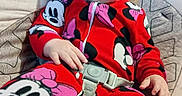 Arianna is registered to the contest to win money with this photo: child, toddler, portrait, smiling, happy, sitting, couch, pajamas, red_clothing, disney_character, minnie_mouse, mickey_mouse, seatbelt, indoors, home, living_room, brown_hair, blonde_hair, cushion, casual_photo
