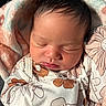 newborn, baby, sleeping, blanket, floral_pattern, infant, soft, peaceful, cute, face, head, clothing, portrait, closeup, skin, resting, indoors, cozy, wrapped, toddler