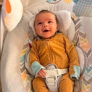 Delilah is registered to the contest to win money with this photo: baby, infant, smiling, onesie, baby_swing, plush_toys, pastel_colors, cushion, happy, indoor, child, face, footed_pajamas, seat_belt, head_support, patterned_fabric, soft_toys, baby_clothing, baby_accessory, baby_bed