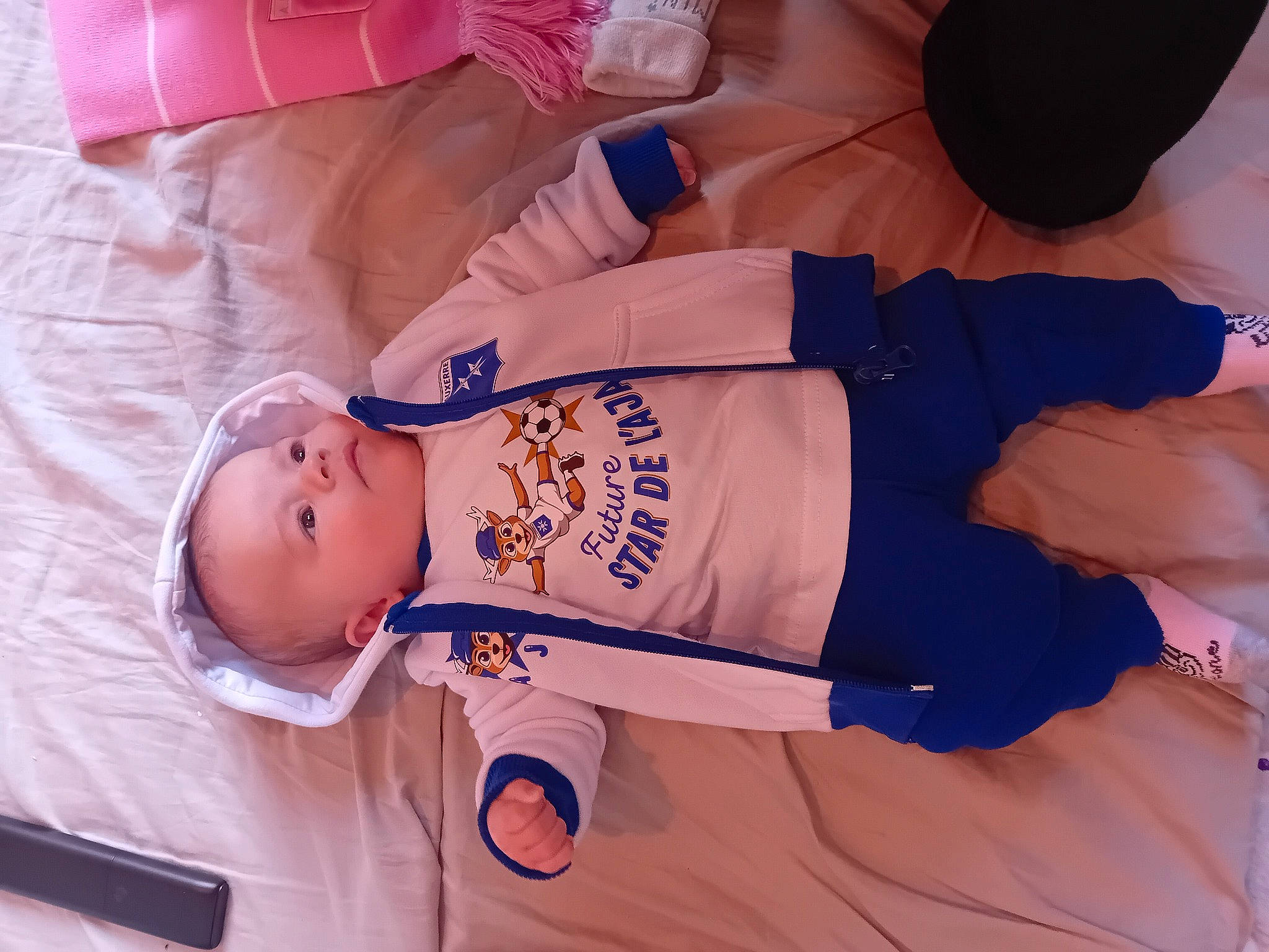 Hanaë participe au concours pour gagner de l'argent avec cette photo : baby, baby_products, baby_sleeping, baby_toddler_clothing, child, comfort, elbow, electric_blue, finger, hand, knee, linens, mammal, orange, person, room, sitting, sleeve, t_shirt, toddler