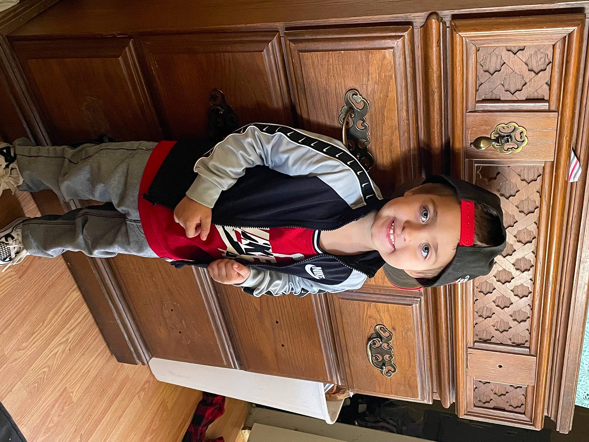 Jaxyn is registered to the contest to win money with this photo: baby, baby_toddler_clothing, cabinetry, child, comfort, cupboard, flooring, happy, hardwood, headwear, joy, person, room, sitting, sleeve, thigh, toddler, varnish, wood, wood_flooring