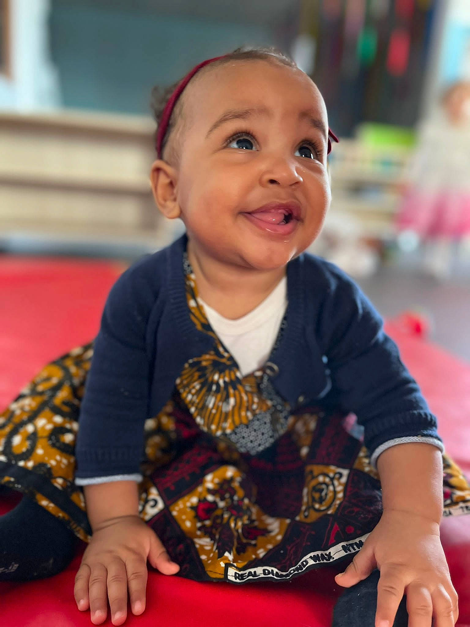 Aylia participe au concours pour gagner de l'argent avec cette photo : baby, baby_toddler_clothing, cheek, child, event, facial_expression, flooring, fun, happy, head, iris, leisure, pattern, person, play, recreation, sitting, skin, sleeve, smile