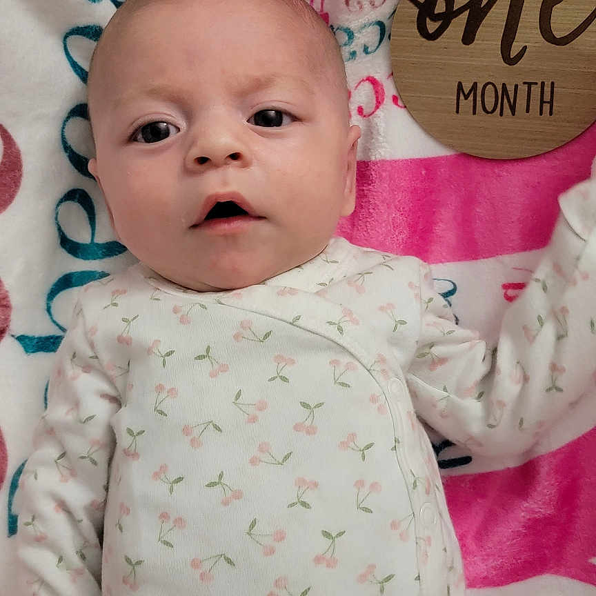 Rebecca is registered to the contest to win money with this photo: applique, baby, bed, bedroom, blanket, bodypart, bonnet, clothing, crib, cushion, face, finger, furniture, glove, hand, hat, head, homedecor, indoors, infantbed