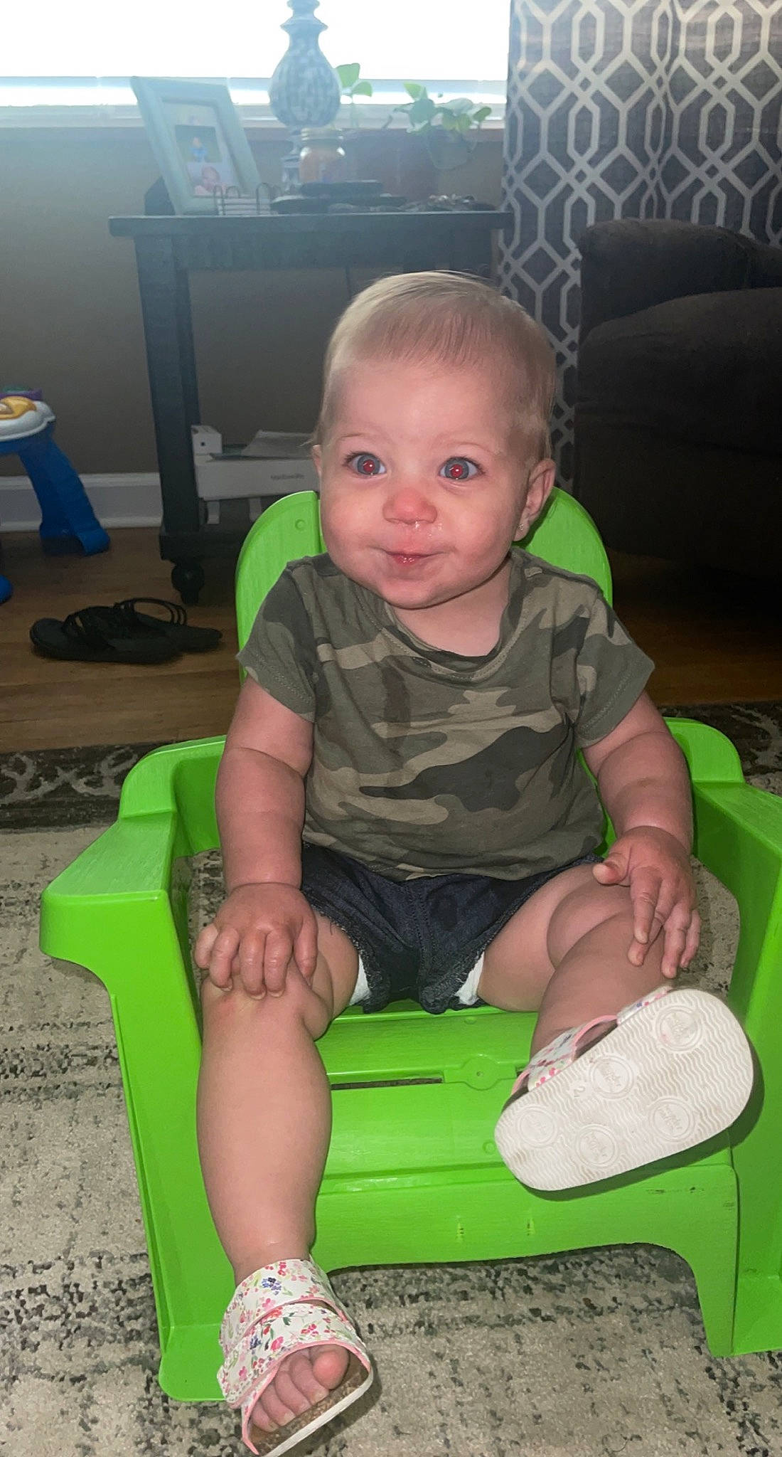 Hadlee is registered to the contest to win money with this photo: baby_toddler_clothing, chair, cheek, child, comfort, facial_expression, finger, flooring, fun, hairstyle, knee, lap, leg, person, skin, sleeve, smile, sock, standing, thigh