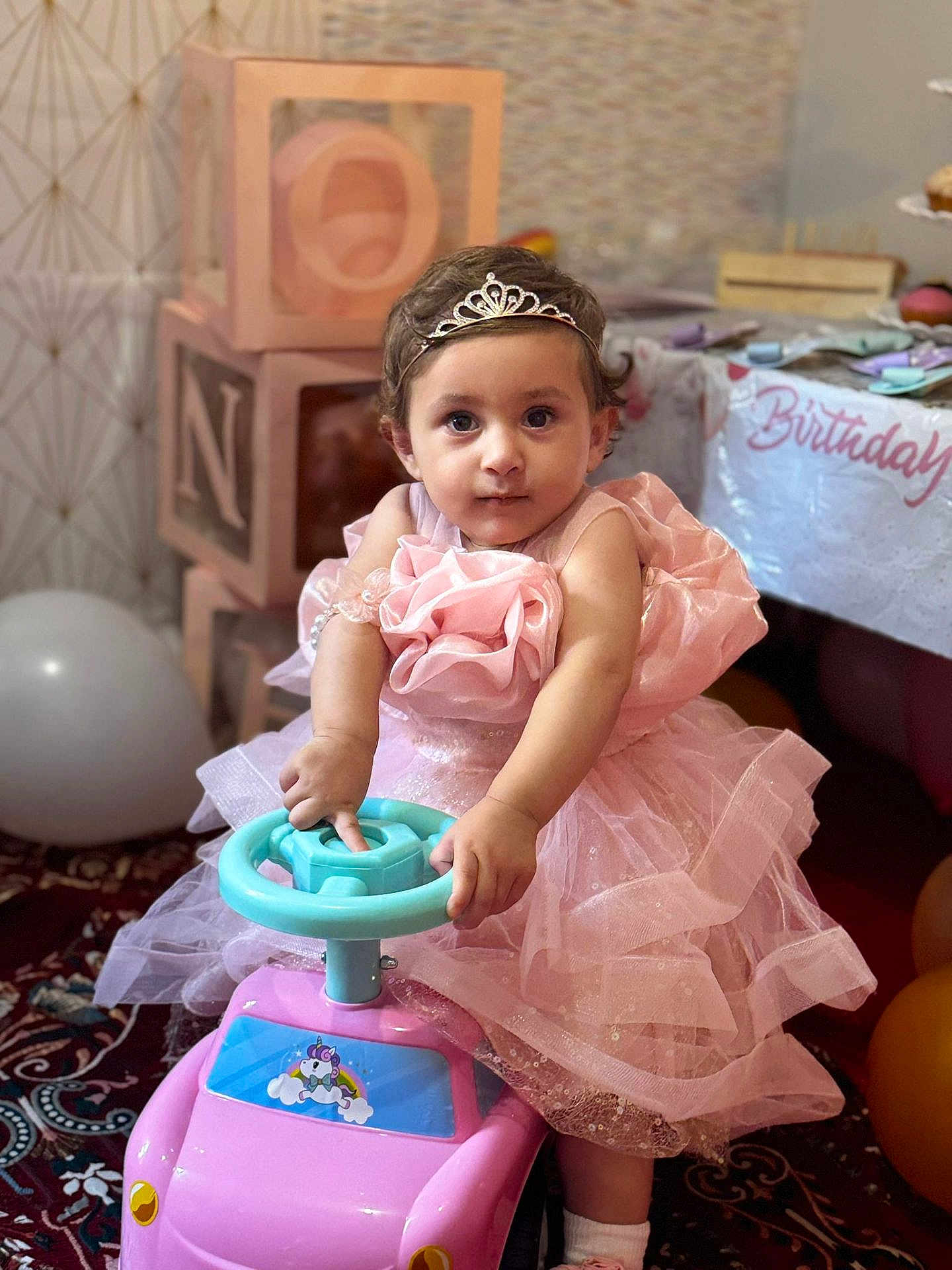 Mirha is registered to the contest to win money with this photo: child, toddler, pink_dress, tiara, toy_car, birthday, balloons, party, celebration, indoor, carpet, blocks, decorations, cute, portrait, girl, play, happy, event, person