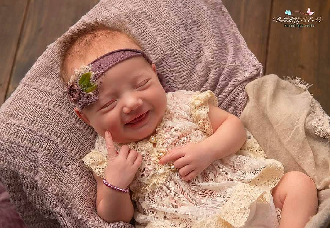 Kadince is registered to the contest to win money with this photo: baby, baby_toddler_clothing, cheek, child, comfort, dress, embellishment, face, finger, flash_photography, gesture, happy, headgear, headpiece, iris, joy, person, pink, skin, smile