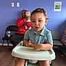 Marcus Nay joined the competition — help win amazing prizes! toddler, baby, caregiver, high_chair, sitting, portrait, child, infant, indoor, waiting_room, blue_wall, red_shirt, polo_shirt, curious, serious_expression, family, chairs, baby_bottle, wood_floor, daylight
