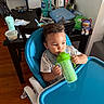 Marcus Nay is registered to the contest to win money with this photo: astronaut_toy, baby, casual, chair, child, dining_table, drinking, feeding, furniture, high_chair, home, household, indoors, kitchen, portrait, short_hair, sippy_cup, smiling, toddler, toy