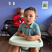 Marcus Nay is registered to the contest to win money with this photo: baby, blue_wall, bottle, chairs, child, classroom, cuddling, daycare, family, father, high_chair, indoor, infant, polo_shirt, portrait, red_shirt, sitting, smiling, toddler, wood_floor