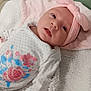 Lilly Grace is registered to the contest to win money with this photo: baby, infant, headband, pink, bow, flower_print, onesie, blanket, soft_texture, sleeping_area, cute, child, newborn, portrait, lying_down, indoors, cozy, baby_clothes, face, curious