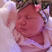 Lilly Grace joined the competition — help win amazing prizes! baby, newborn, sleeping, blanket, headband, floral, pink_clothing, cute, infant, face, soft_texture, wrapped, peaceful, child, portrait, indoors, cozy, resting, toddler, adorable