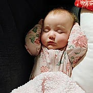 Journey is registered to the contest to win money with this photo: baby, sleeping, floral_onesie, blanket, cozy, infant, child, peaceful, face, closed_eyes, soft_lighting, indoors, couch, pink, cute, portrait, resting, hands_up, toddler, warm
