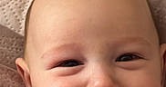 Axel Gael is registered to the contest to win money with this photo: baby, blanket, child, chubby_cheeks, close_up, cozy, cute, expression, face, happy, head, indoors, infant, person, pillow, portrait, red_blanket, skin, smile, young