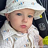 baby, baby_fashion, blue_eyes, bucket_hat, car_seat, child, close_up, clothing, cute, hat, indoor, infant, patterned_clothing, person, plush_toy, portrait, seat, serious_expression, shirt, small_toy
