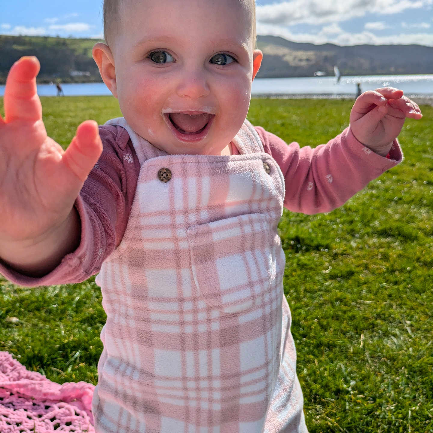 Fflur Mai is registered to the contest to win money with this photo: baby, bodypart, clothing, face, finger, grass, hand, happy, head, lawn, nature, outdoors, pants, person, photography, plant, portrait, shirt, smile, t_shirt