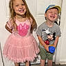 child, girl, boy, smiling, dress, tshirt, cap, toy, crocs, shoes, floor, door, indoors, happy, standing, playful, kids, portrait, casual, cute