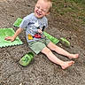 child, boy, smiling, barefoot, mickey_mouse, tshirt, green_shoes, foam_mats, outdoor, gravel_path, grass, trees, play, summer, people, group, casual_clothing, happy, nature, sunny