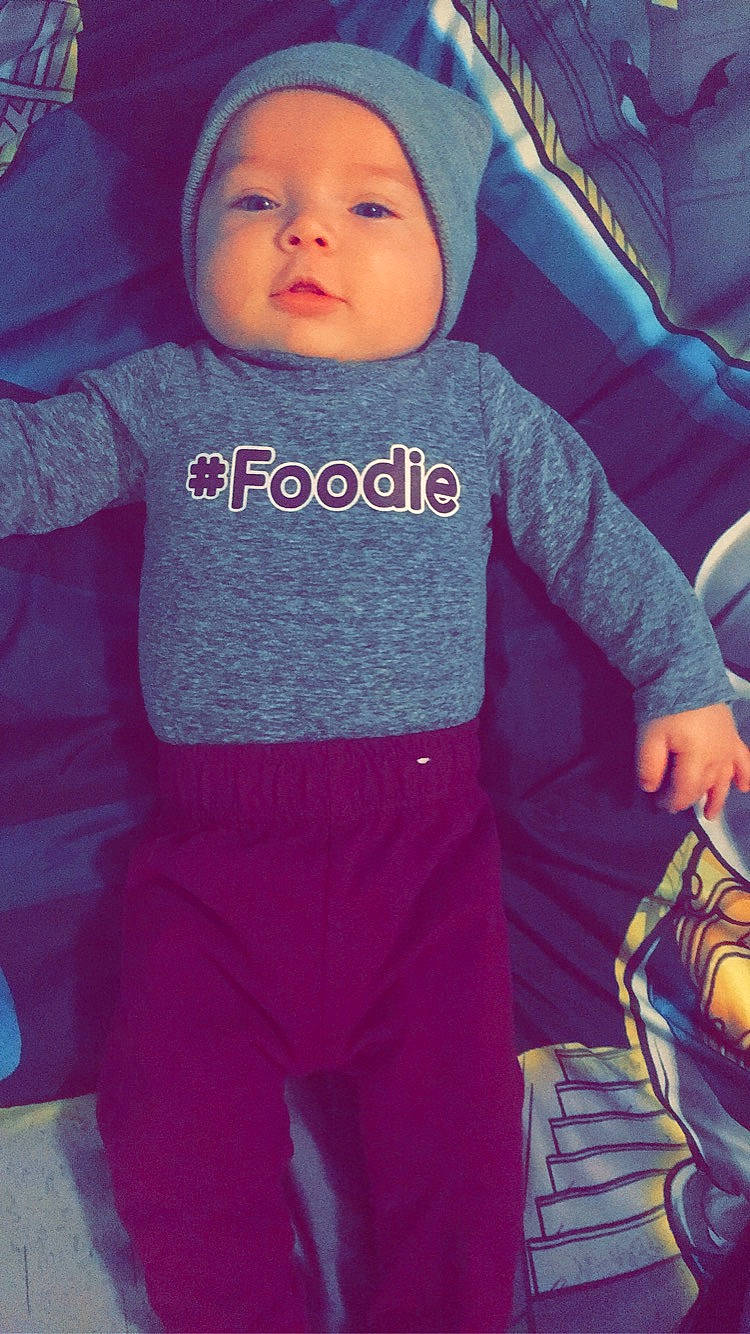 Mason is registered to the contest to win money with this photo: baby, baby_toddler_clothing, cool, face, facial_expression, gesture, hand, happy, head, headgear, headwear, human, organ, outerwear, person, photograph, shoulder, sleeve, sportswear, t_shirt