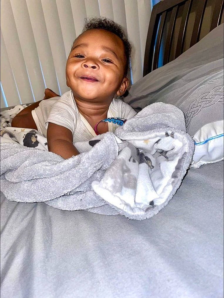 Lamar joined the competition — help win amazing prizes! baby, baby_products, baby_toddler_clothing, bed, bedding, bedroom, child, comfort, face, floor, flooring, fun, happy, infant_bed, linens, person, sitting, sleeve, smile, thumb