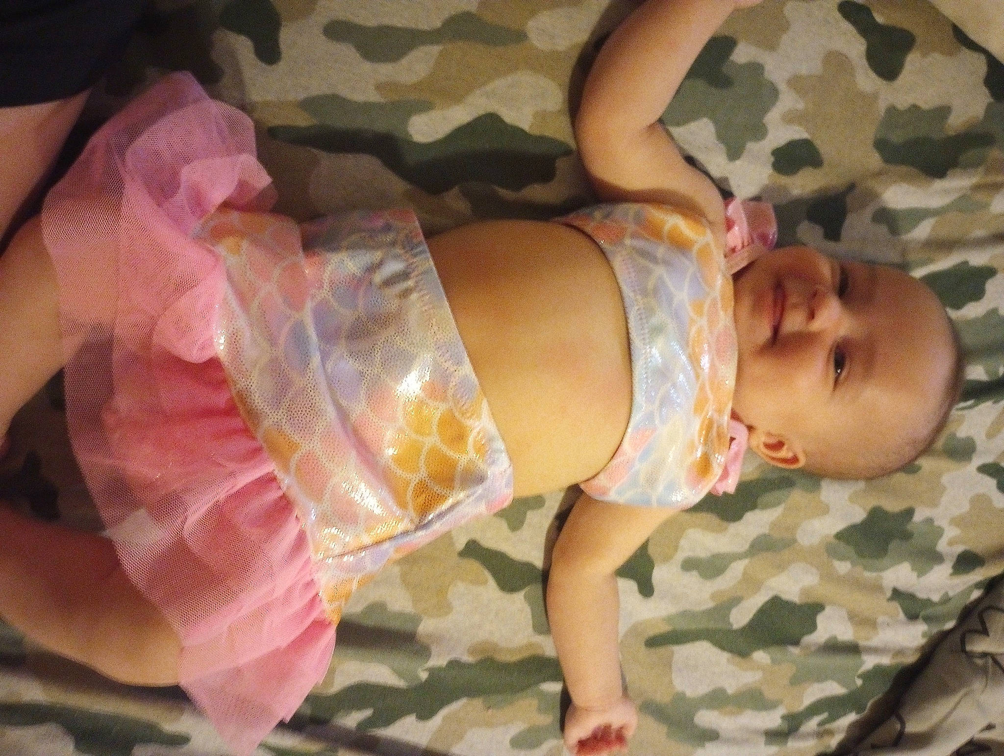 Angelica is registered to the contest to win money with this photo: baby, baby_products, baby_toddler_clothing, child, comfort, dress, foot, fun, hand, human_body, human_leg, leg, linens, pattern, person, pink, room, skin, smile, thigh