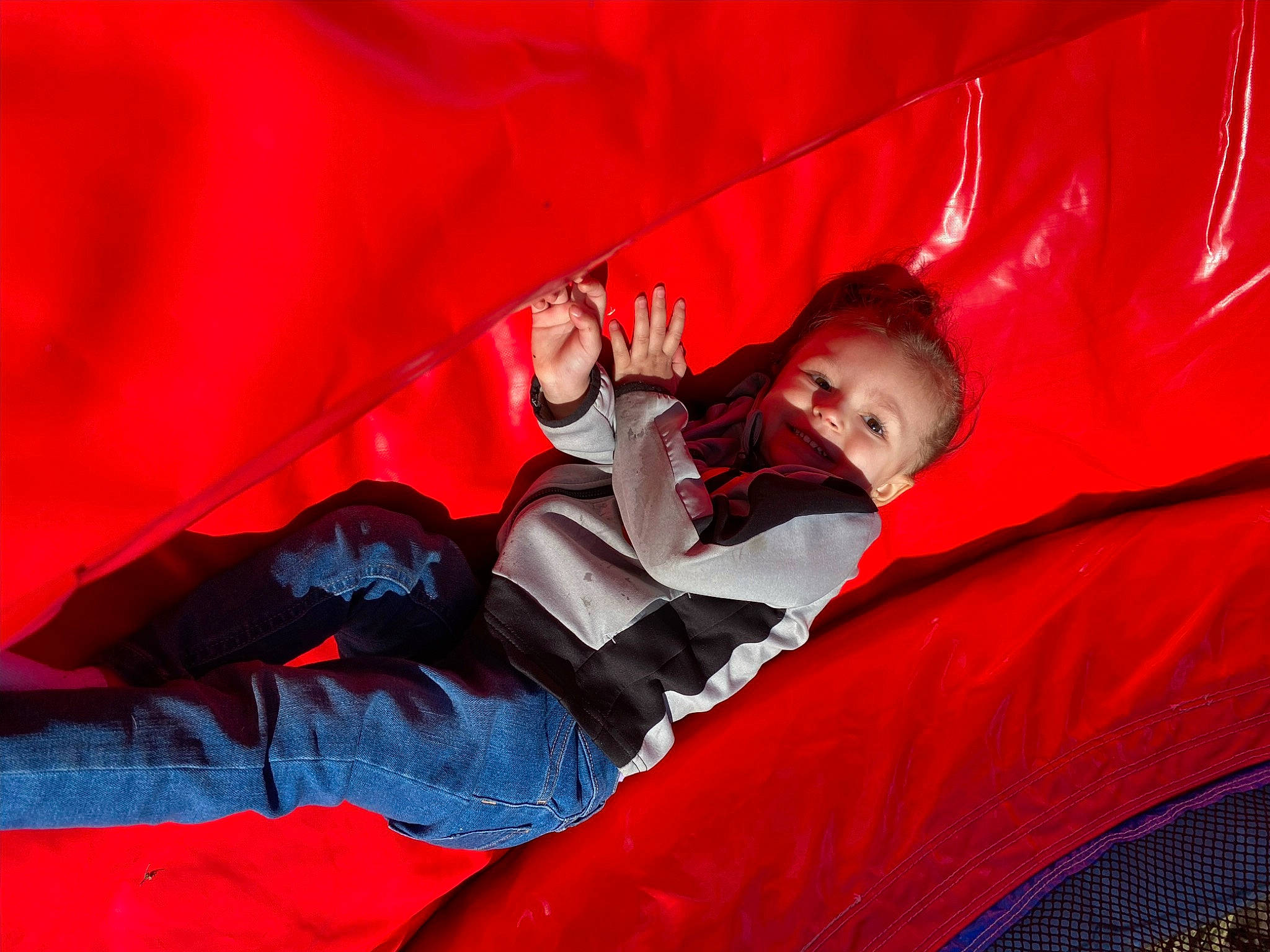 Avery is registered to the contest to win money with this photo: automotive_design, carmine, comfort, event, fun, grass, inflatable, leisure, magenta, person, recreation, sitting, smile, tints_and_shades, toddler, tree