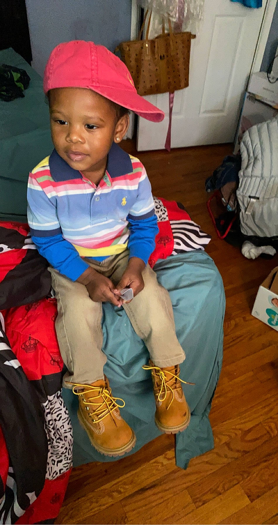 Shavon is registered to the contest to win money with this photo: baby, baby_toddler_clothing, backpack, bag, baggage, baseball_cap, bonnet, boot, box, cap, child, clothing, person, sock, toddler