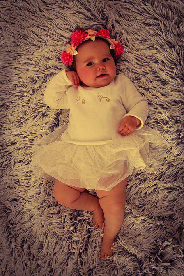 Lison a rejoint le concours — aidez-le/la à gagner de superbes lots ! baby, baby_toddler_clothing, beauty, day_dress, dress, embellishment, facial_expression, flower, fun, grass, happy, headgear, headpiece, headwear, iris, lip, person, petal, pink, skin