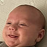 Matthew is registered to the contest to win money with this photo: baby, smiling, face, close_up, infant, tongue, skin, head, ear, cheeks, expression, cute, newborn, lying_down, texture, blanket, happy, person, portrait, indoors