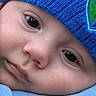 baby, face, close_up, hat, blue_hat, infant, child, skin, eyes, nose, mouth, clothing, knit, warm, soft, cute, young, portrait, headwear, expression