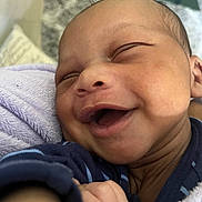 Kyrie Parker is registered to the contest to win money with this photo: baby, smiling, face, closeup, infant, blanket, purple_blanket, happy, skin, person, newborn, sleepy, cute, child, portrait, indoors, clothing, warm, cozy, hand