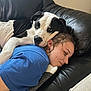 dog, person, couch, black_leather, blue_shirt, resting, head, pet, companion, indoor, relaxing, affection, animal, human, closeup, comfort, casual, friendship, cozy, nap_time