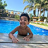 Zayn joined the competition — help win amazing prizes! child, boy, smiling, happy, pool, swimming_pool, outdoor, sunny, tropical, palm_trees, water, vacation, resort, poolside, portrait, curly_hair, grinning, bare_shoulders, lounge_chairs, nature