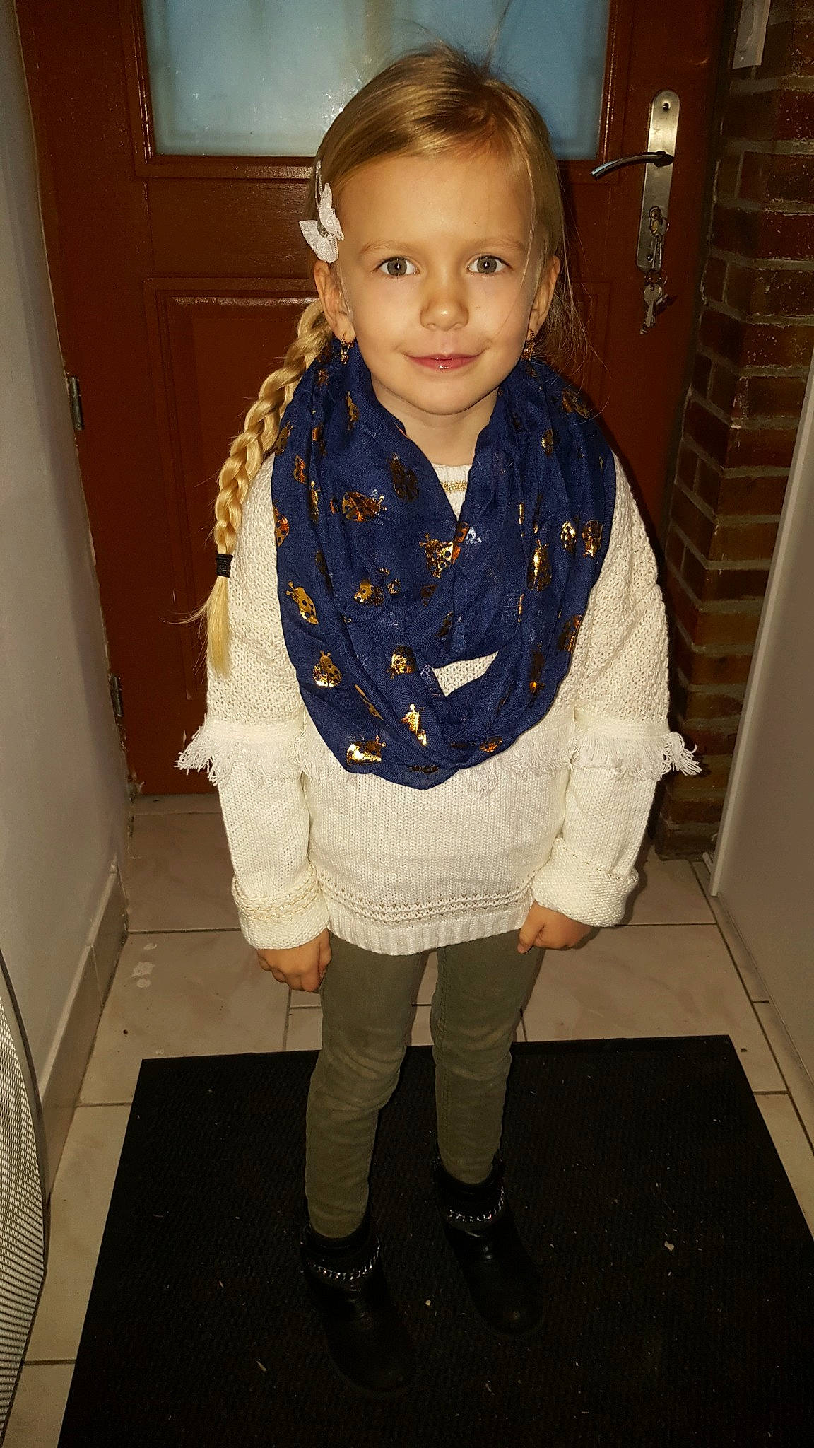Rose participe au concours pour gagner de l'argent avec cette photo : child, fashion_accessory, flooring, fun, girl, jeans, knitting, material, outerwear, pattern, person, product, scarf, smile, standing, sweater, textile, toddler