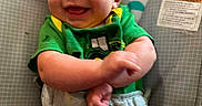 Braylen is registered to the contest to win money with this photo: baby, smiling, green_shirt, diaper, baby_chair, monkey_design, rainbow, infant, cute, happy, child, crossed_arms, indoor, person, young_child, comfort, playful, seat, toddler, clothing