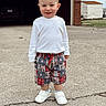 Bodhi is registered to the contest to win money with this photo: baseball_pattern, boy, casual, child, clothing, concrete_driveway, daytime, garage, happy, outdoor, person, plaid_shorts, shed, shorts, smiling, standing, toddler, white_shirt, white_shoes, young_child