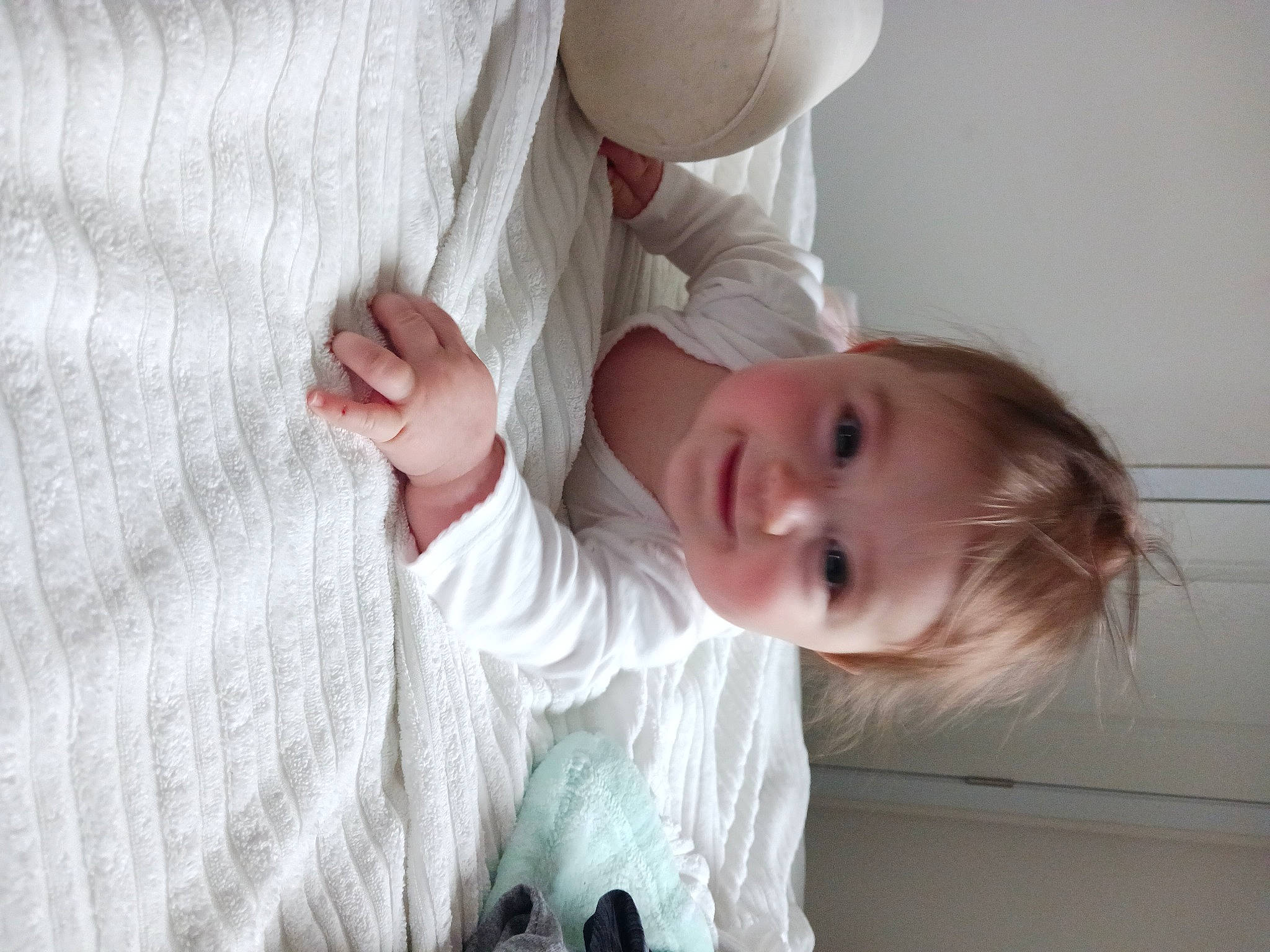 Julia is registered to the contest to win money with this photo: baby, baby_toddler_clothing, camera, child, comfort, flooring, gesture, happy, linens, nose, pattern, person, portrait_photography, room, sleeve, smile, toddler, wood