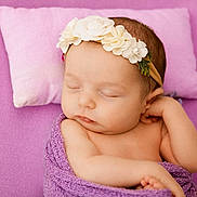 Sierra is registered to the contest to win money with this photo: baby, sleeping, infant, purple_blanket, floral_headband, pink_pillow, soft_texture, peaceful, cute, newborn, wrapped, resting, child, portrait, closeup, skin, face, hand, cozy, adorable