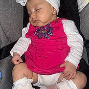 Lahna participe au concours pour gagner de l'argent avec cette photo : baby, sleeping, car_seat, pink_clothing, headband, lace, footwear, white_socks, infant, child, cute, peaceful, toddler, soft_lighting, indoor, portrait, small_hands, closed_eyes, comfortable, resting