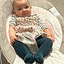 baby, infant, baby_rocker, clothing, tights, floral_pattern, indoor, flooring, baby_seat, smiling, cute, child, portrait, soft_lighting, cozy, small_hands, expression, fabric, baby_accessory, comfortable