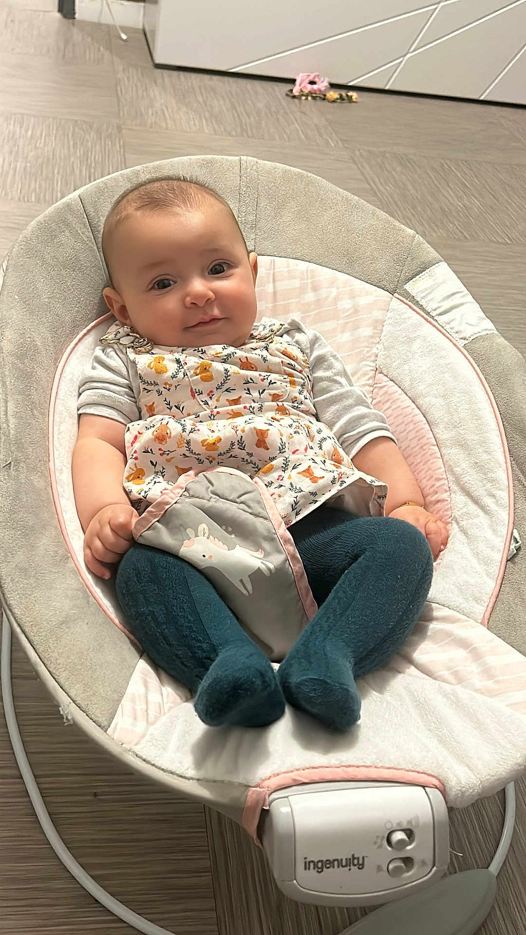 Lahna participe au concours pour gagner de l'argent avec cette photo : baby, infant, baby_rocker, clothing, tights, floral_pattern, indoor, flooring, baby_seat, smiling, cute, child, portrait, soft_lighting, cozy, small_hands, expression, fabric, baby_accessory, comfortable