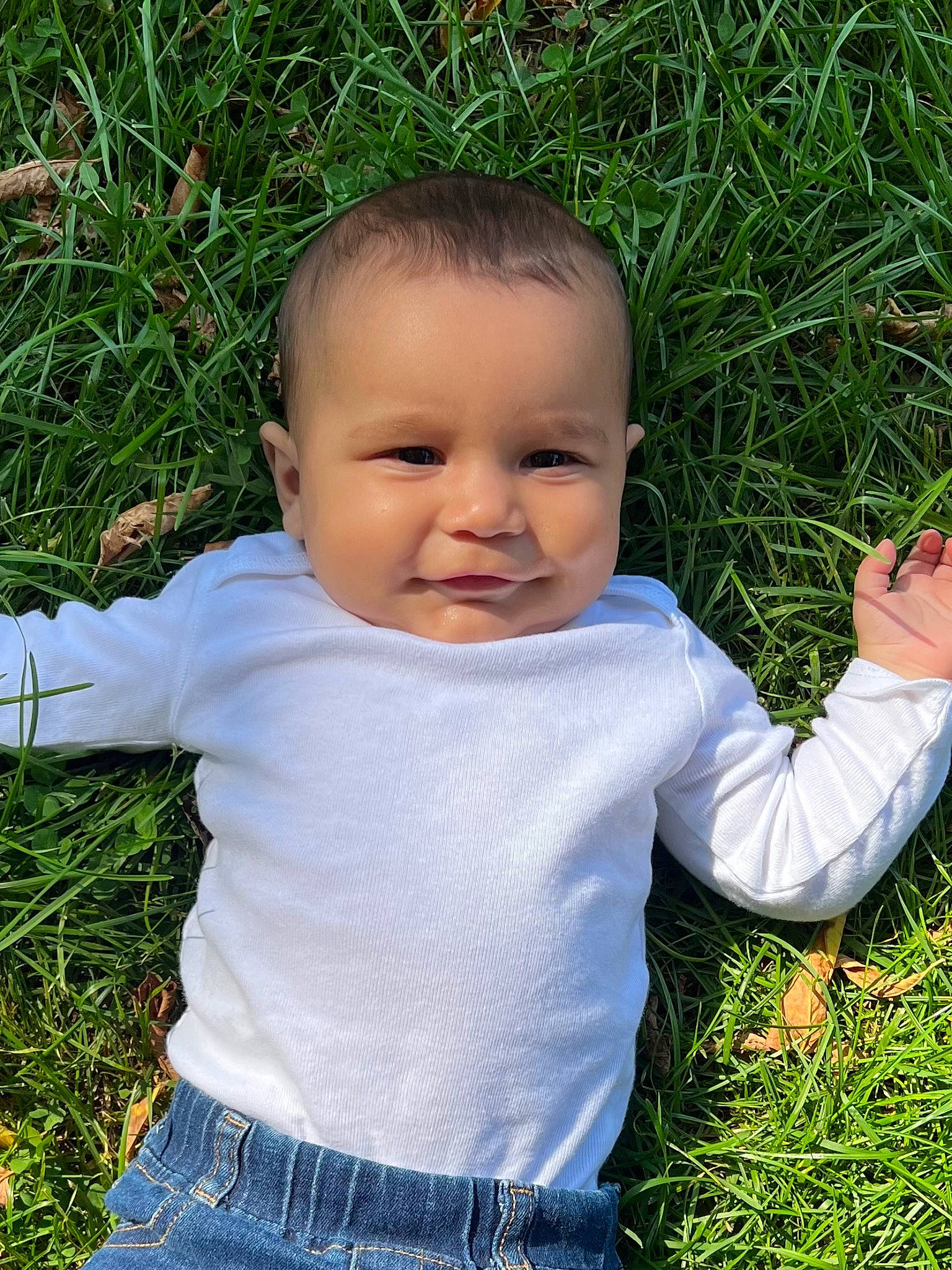 August is registered to the contest to win money with this photo: baby, baby_toddler_clothing, child, clothing, fun, gesture, grass, grass_family, grassland, happy, joy, lawn, meadow, nose, people_in_nature, person, plant, sitting, skin, sleeve