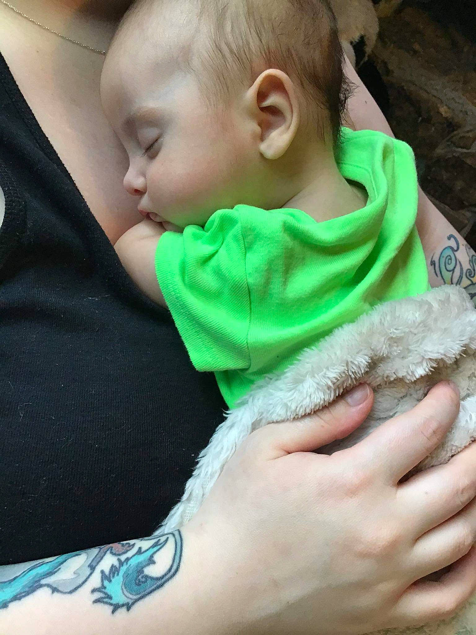 Tobias is registered to the contest to win money with this photo: baby, baby_toddler_clothing, bib, child, comfort, finger, grass, hand, happy, linens, mouth, nail, neck, pattern, person, sitting, skin, sleeve, t_shirt, textile