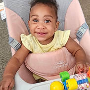Kalii is registered to the contest to win money with this photo: baby, baby_chair, bright_eyes, carpet, child, clothing, colorful, curly_hair, face, furniture, hand, happy, indoor, person, playtime, seat, smiling, toddler, toy, young_child