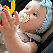 Harley joined the competition — help win amazing prizes! baby, pacifier, headband, blue_eyes, car_seat, toy, hand, harness, warning_label, clothing, child, infant, seatbelt, closeup, indoor, cute, expression, person, accessory, safety