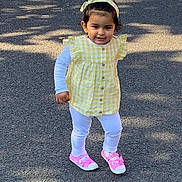 Anokhi is registered to the contest to win money with this photo: toddler, child, yellow_checkered, headband, pink_shoes, white_leggings, outdoor, pavement, sunlight, shadow, cute, walking, happy, person, young_child, casual_clothing, daytime, smiling, fashion, playful