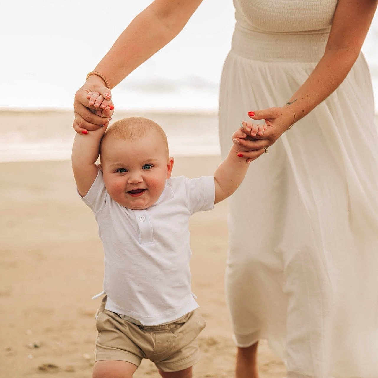 Tate joined the competition — help win amazing prizes! adult, baby, barefoot, beach, child, dress, first_steps, hand_holding, happy, nature, outdoor, parent, sand, shorts, smiling, summer, support, walking, white_shirt, woman