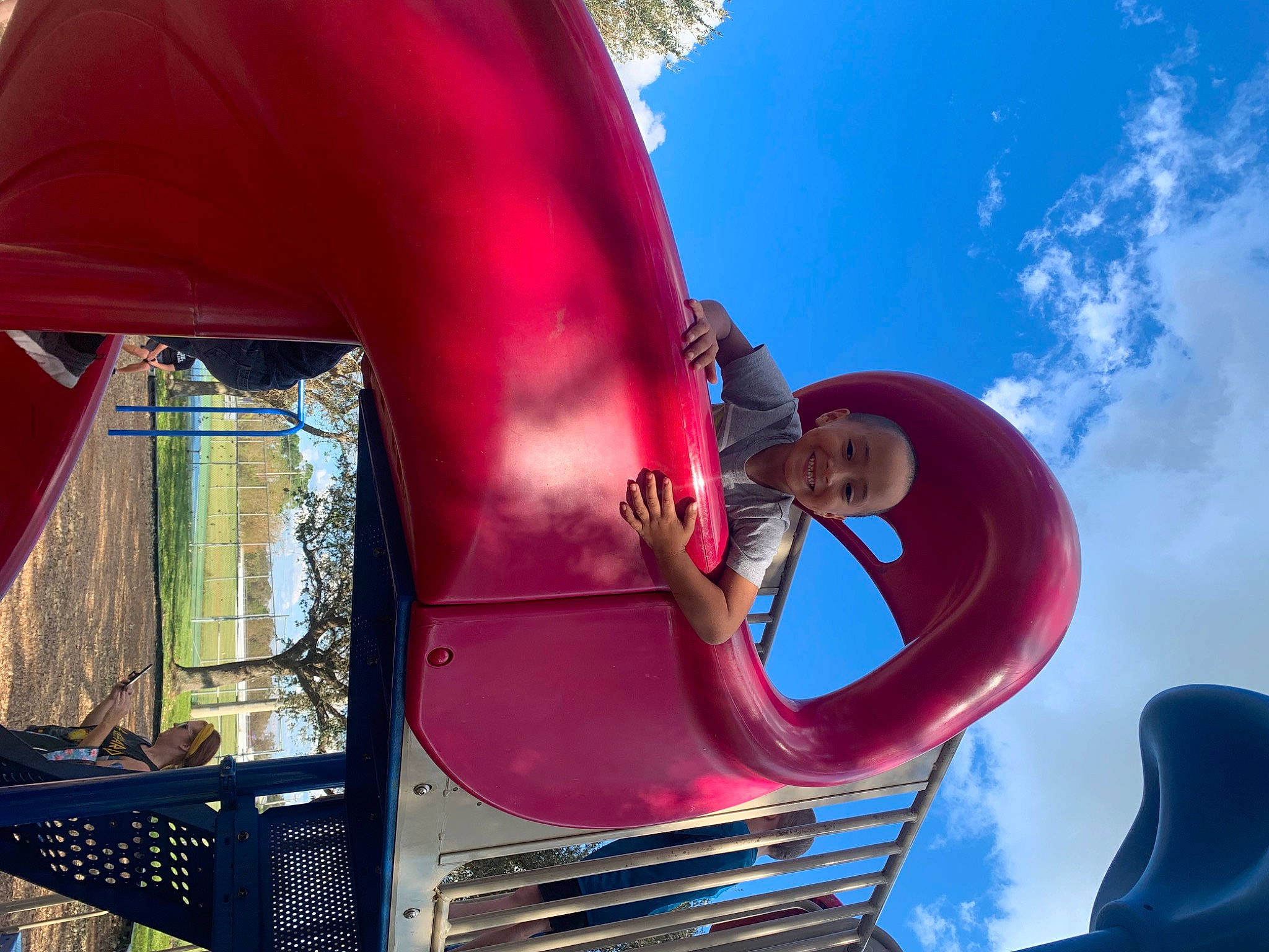 Jace is registered to the contest to win money with this photo: auto_part, automotive_design, automotive_exterior, automotive_lighting, automotive_tire, automotive_wheel_system, bumper, chute, cloud, fun, hood, joy, leisure, magenta, motor_vehicle, outdoor_play_equipment, person, pink, red, sky